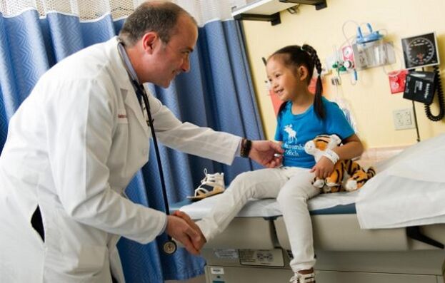 um médico examina uma criança com artrose de quadril